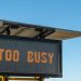 a sign with the words too busy written on it