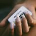 a woman's hand holding a cell phone with a message on it